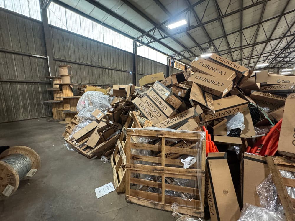Piled cardboard boxes and pallets in a warehouse setting, showcasing clutter and disorganization.